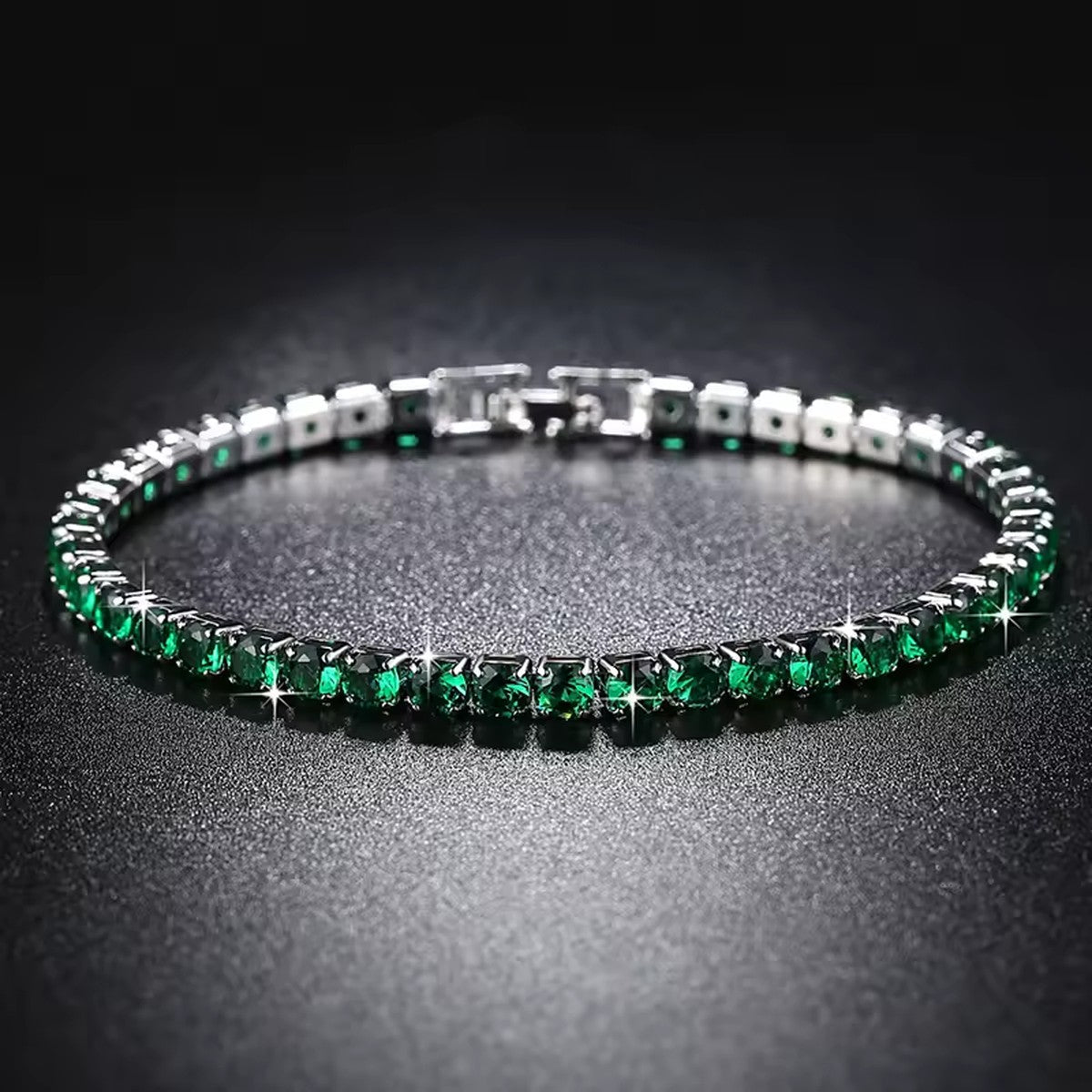 Pulseira Riviera Esmeralda em fundo preto, zircônias verdes brilhando